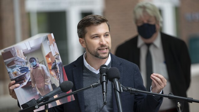 Gabriel Nadeau-Dubois tient une photo durant un point de presse.