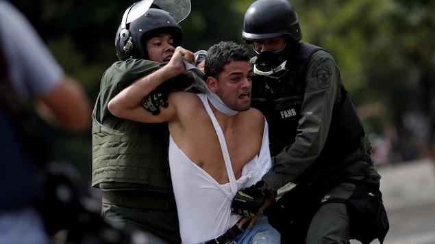 Deux policiers tentent de maîtriser un manifestant, à Caracas le 27 juillet 2017 Deux policiers tentent de maîtriser un manifestant, à Caracas le 27 juillet 2017