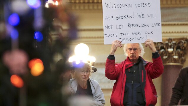 Un manifestant à l'intérieur de la législature d'État du Wisconsin, à Madison. Un manifestant à l'intérieur de la législature d'État du Wisconsin, à Madison.