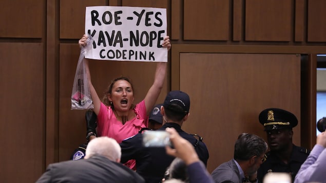 Une manifestante brandit une affiche.