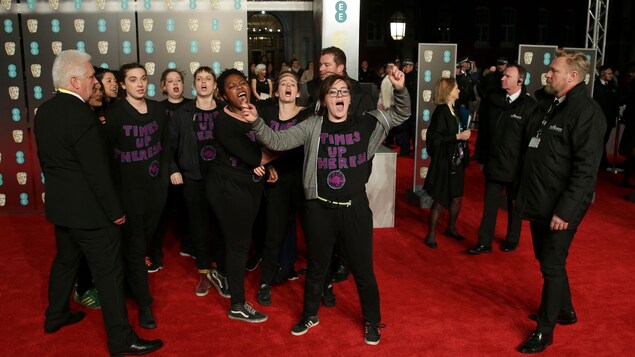 Des manifestantes qui portaient un chandail « Times Up Theresa » (du prénom de la première ministre britannique) ont envahi le tapis rouge des prix BAFTA Des manifestantes qui portaient un chandail « Times Up Theresa » (du prénom de la première ministre britannique) ont envahi le tapis rouge des prix BAFTA