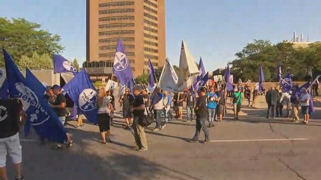 Manifestants avec des drapeaux bleu et blanc devant la tour de Radio-Canada Manifestants avec des drapeaux bleu et blanc devant la tour de Radio-Canada
