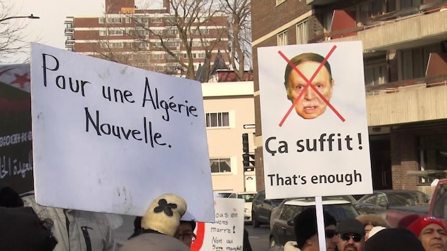 Des manifestants brandissent des pancartes. Sur l'une d'entre elles il est écrit: «Pour une Algérie nouvelle».