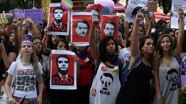 Des manifestantes, certaines le poing levé, d'autres avec des affiches anti-Bolsonaro.