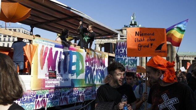 Des manifestants prennent part à une marche contre le racisme à Berlin. Derrière eux, sur une pancarte, on peut lire, en anglais, « Unis contre le racisme ». Des manifestants prennent part à une marche contre le racisme à Berlin. Derrière eux, sur une pancarte, on peut lire, en anglais, « Unis contre le racisme ».