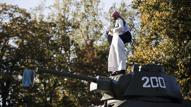 Un manifestant a grimpé sur un char d'assaut. Un manifestant a grimpé sur un char d'assaut.
