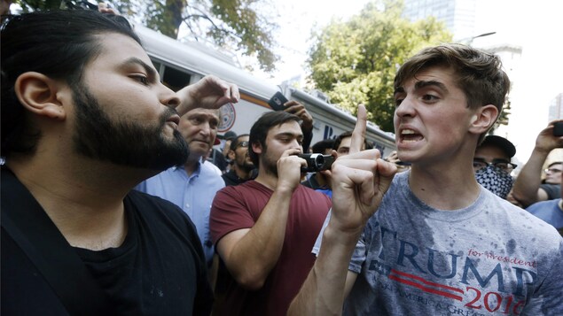 Un militant participant au rassemblement « pour la liberté d’expression », vêtu d'un chandail à l'effigie du président Donald Trump, argumente avec un manifestant antiraciste, à Boston. Un militant participant au rassemblement « pour la liberté d’expression », vêtu d'un chandail à l'effigie du président Donald Trump, argumente avec un manifestant antiraciste, à Boston.