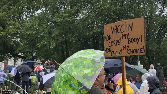 Un manifestant brandissant une affiche contre le vaccin.