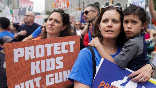 « Protégez nos enfants, pas les armes », lit-on sur la pancarte d'une manifestante, au milieu d'une foule. 