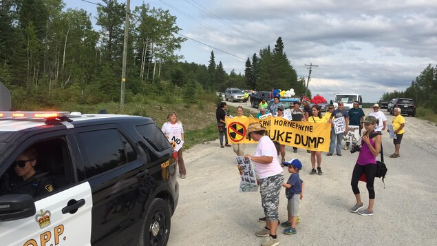 Des manifestants escortés par une voiture de police.
