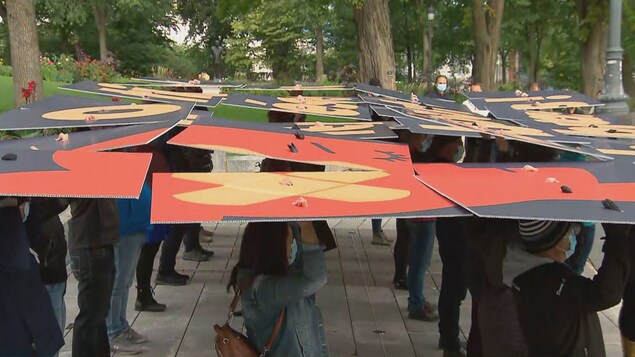 Les manifestants tiennent des pancartes au-dessus de leurs têtes.