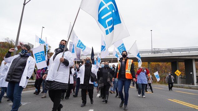 Des membres de la FIQ brandissent des drapeaux.