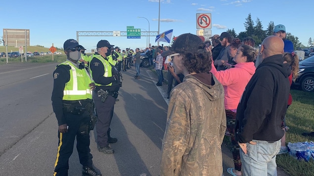 De nombreux policiers tentent de disperser les manifestants qui bloquent l'autoroute entre le Nouveau-Brunswick et la Nouvelle-Écosse, mercredi soir.