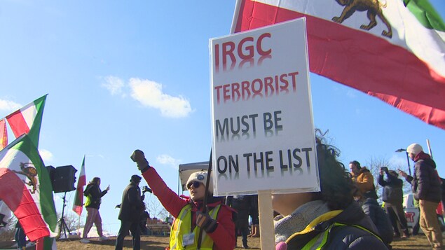 Mga nagpoprotesta na may hawak na watawat ng Iran at isang placard na nagsasabing 'IRGC terrorist must be on the list.' 