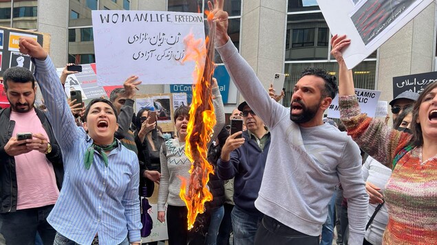 Des manifestants brûlent un hijab, 