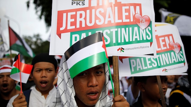 Des manifestants tiennent des pancartes où l'on peut lire : « Libérez Jérusalem pour tous les Palestiniens ». Des manifestants tiennent des pancartes où l'on peut lire : « Libérez Jérusalem pour tous les Palestiniens ».