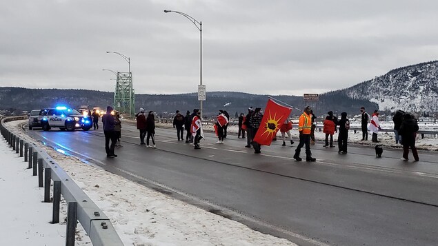Manifestants près du pont avec des drapeaux.