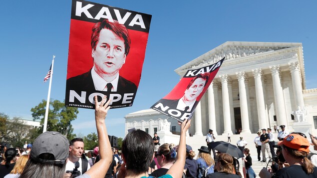 Des manifestants brandissent des pancartes disant « Kava- nope ».