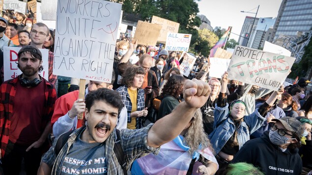 Un manifestant pro-droits LGBTQ+, le poing levé.