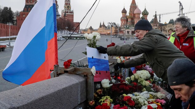Des gens déposent des fleurs à l'endroit où a été assassiné l'opposant politique russe Boris Nemstov, près du Kremlin, après un rassemblement en son honneur, à Moscou.