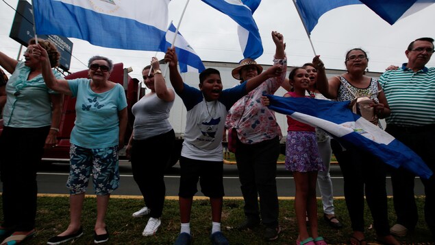 Des manifestants agitent des drapeaux du Nicaragua. Des manifestants agitent des drapeaux du Nicaragua.
