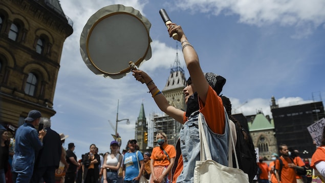 Une manifestante joue du tambour. 