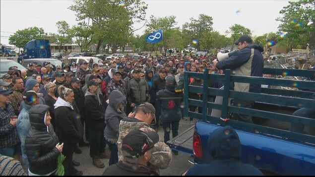 Un pêcheur fait un discours devant les autres pêcheurs rassemblés devant lui avec un porte-voix. Un pêcheur fait un discours devant les autres pêcheurs rassemblés devant lui avec un porte-voix.