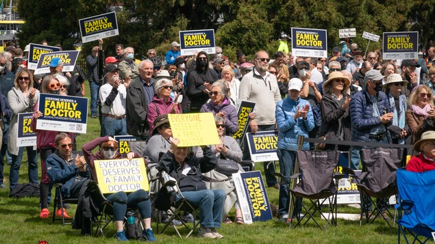 Des personnes avec des affiches à la manifestation en soutien aux médecins de famille à Victoria, le 19 mai 2022. 