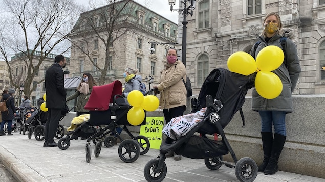 Des parents avec des masques et des poussettes.