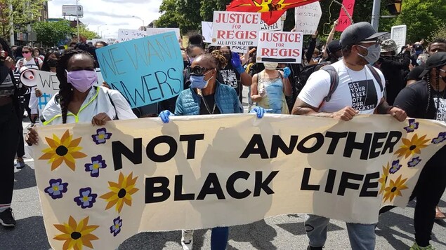 Les manifestants tiennent une banderole portant le message « pas une autre vie d'un Noir perdue ».