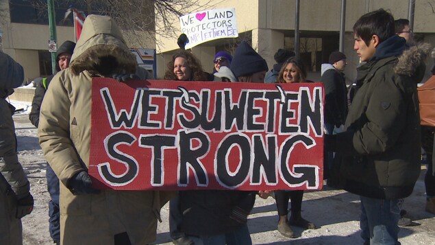 Un manifestant porte une pancarte où il est écrit « Wet'suwet'en strong ».