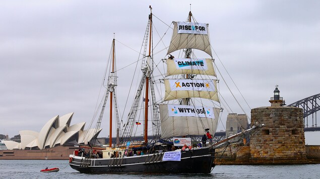 Une goélette avec des banderoles dénonçant les changements climatiques devant l'opéra de Sydney Une goélette avec des banderoles dénonçant les changements climatiques devant l'opéra de Sydney