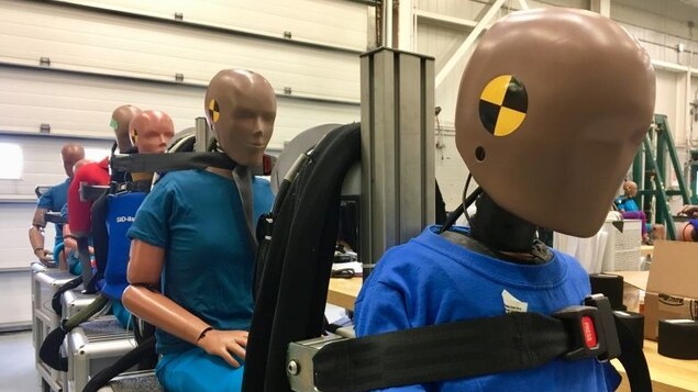 Assis sur des sièges, des mannequins portent des ceintures de sécurité. Assis sur des sièges, des mannequins portent des ceintures de sécurité.