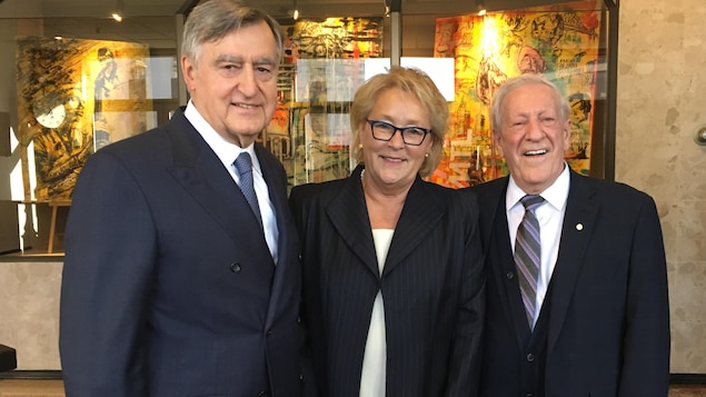 Deux hommes âgés et une femme blonde sourient à la caméra. Deux hommes âgés et une femme blonde sourient à la caméra.