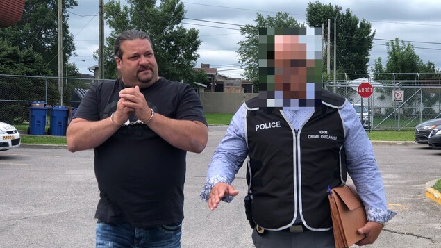 Menotté, un homme marche à côté d'un policier. Menotté, un homme marche à côté d'un policier.