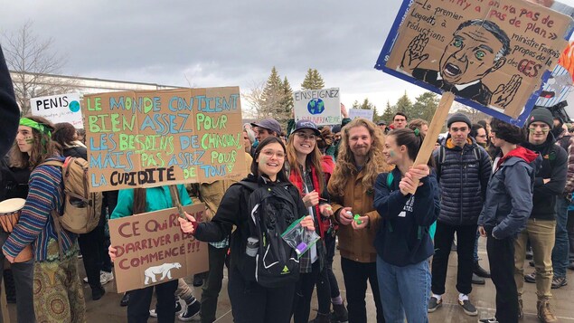 Des milliers d'étudiants rassemblés à l'Université de Sherbrooke avant leur départ pour la marche pour le climat. Ils transportent des pancartes, dont l'une se lit : « Enseignez à sauver la Terre »