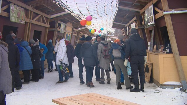 Des gens marchent dans un marché public pendant l'hiver.