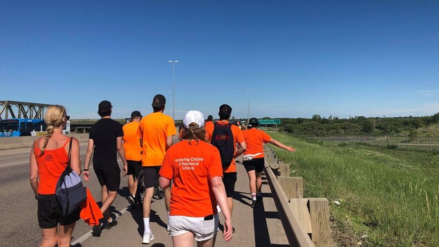 Des gens marchent sur le Circle Drive à Saskatoon pour promouvoir les appels à l'action en faveur de la communauté autochtone.