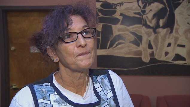 Une dame d'un certain âge avec des lunettes rectangulaires noires et des cheveux aux reflets mauves relevés regarde la caméra. Une dame d'un certain âge avec des lunettes rectangulaires noires et des cheveux aux reflets mauves relevés regarde la caméra.