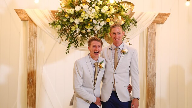 Craig Burns et Luke Sullivan, se tenant par la taille et souriant pour les caméras, se sont mariés quelques minutes après l'entrée en vigueur de la nouvelle loi australienne. Craig Burns et Luke Sullivan, se tenant par la taille et souriant pour les caméras, se sont mariés quelques minutes après l'entrée en vigueur de la nouvelle loi australienne.