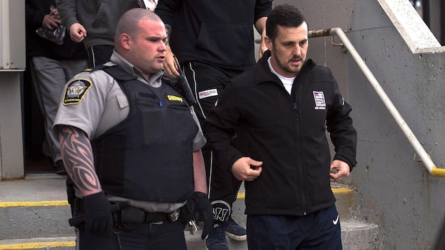 Simon Radford escorté par un policier à sa sortie de la cour provinciale. Simon Radford escorté par un policier à sa sortie de la cour provinciale.