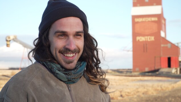 Le chanteur du groupe Ponteix en entrevue devant le silo à grain du village fransaskois Ponteix.