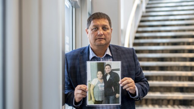 Le chef du Conseil tribal de Saskatoon, Mark Arcand, le 7 septembre 2022, avec une photo de sa soeur tuée lors des attaques au couteau du 4 septembre sur la Nation crie James Smith, en Saskatchewan.