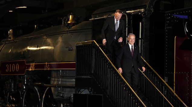 Mark Carney et David McGuinty descendent d'une locomotive avant l'annonce.