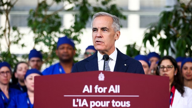 Le premier ministre parle au podium devant des professionnels de la santé.