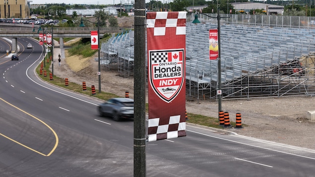 Des banderoles aux couleurs de l’Ontario Honda Dealers Indy sur une rue devant des préparatifs en vue de la course IndyCar qui se tiendra à Markham en Ontario.