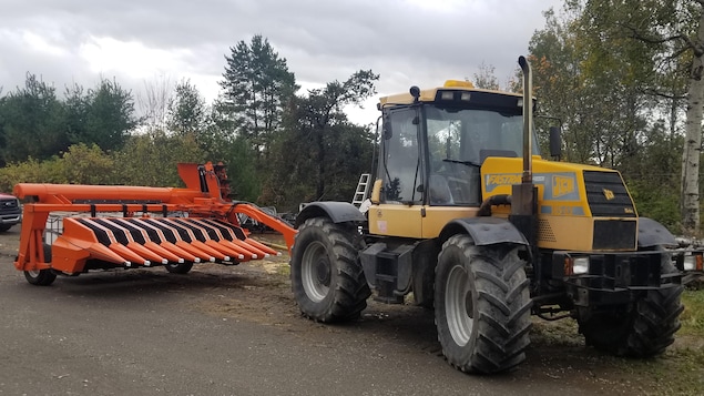 Un tracteur tire une machine.
