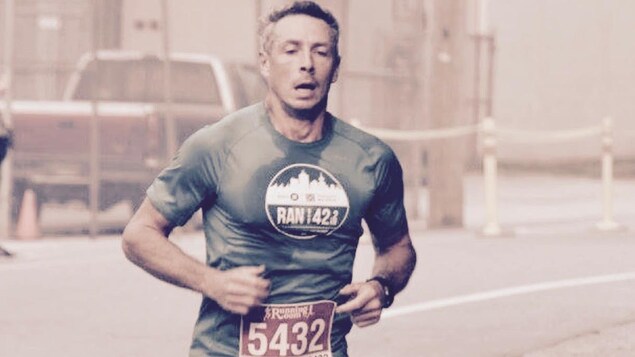 Un homme en vêtements de course en train de courir le long d'un parcours Un homme en vêtements de course en train de courir le long d'un parcours