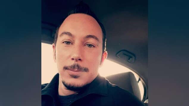 Un homme dans sa voiture.