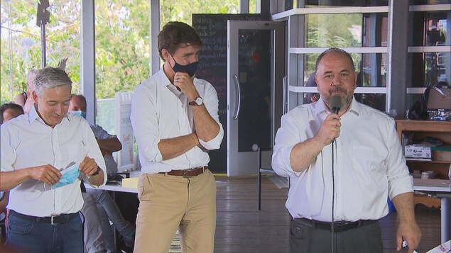 Martin Francoeur au micro qui parle aux côtés de Justin Trudeau et du candidat libéral dans Saint-Maurice Champlain, François-Philippe Champagne.